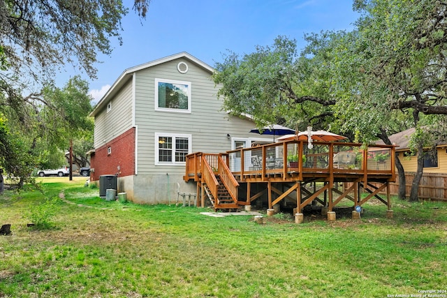 back of property with fence, central air condition unit, stairway, a wooden deck, and a yard