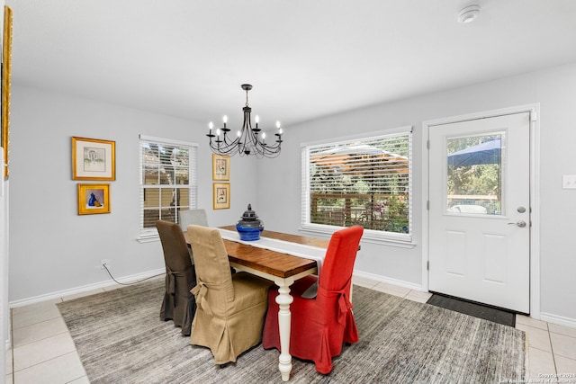 dining space featuring a notable chandelier, light tile patterned floors, and baseboards