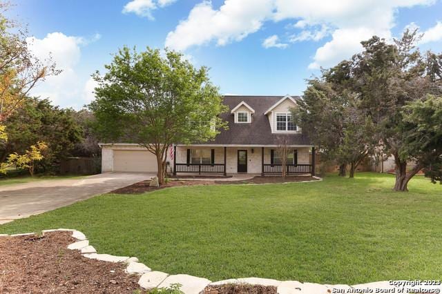 view of front of house featuring a porch, concrete driveway, a front yard, and an attached garage