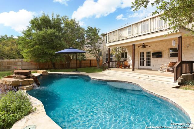 view of pool with a fenced in pool, french doors, a ceiling fan, and a fenced backyard