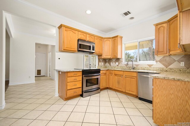 kitchen featuring light tile patterned floors, appliances with stainless steel finishes, and crown molding