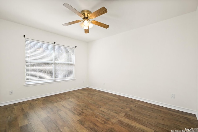 empty room with dark wood finished floors, baseboards, and a ceiling fan