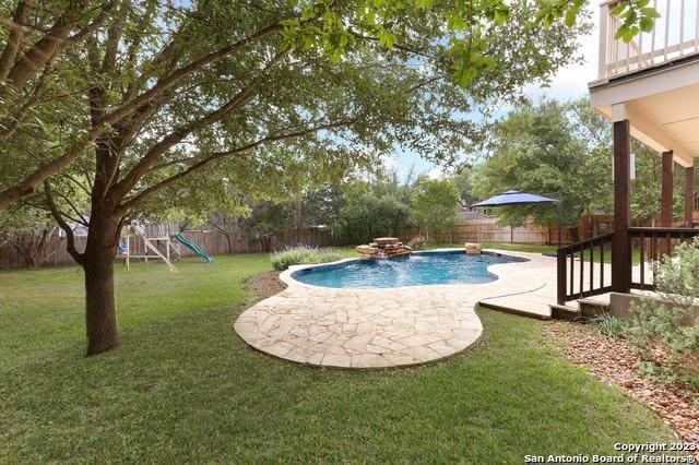 view of swimming pool featuring a fenced in pool, a patio, a fenced backyard, and a playground