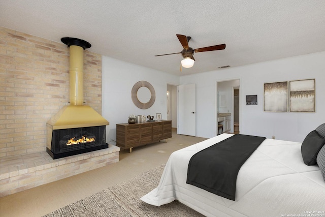 bedroom with visible vents, ensuite bathroom, a ceiling fan, a textured ceiling, and carpet