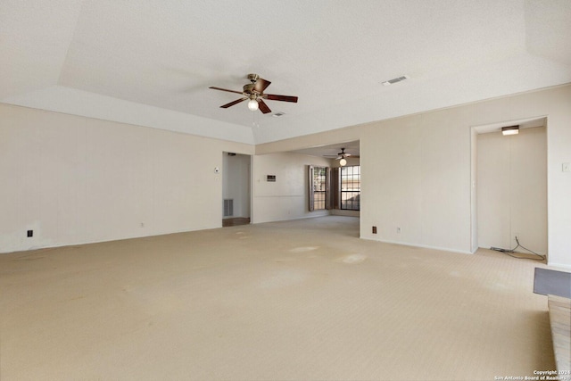 unfurnished living room with visible vents, light carpet, and a ceiling fan