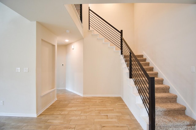 stairway with baseboards and wood finished floors