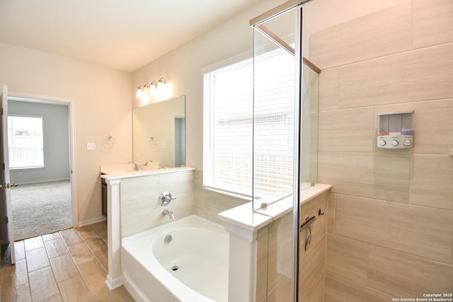 bathroom with vanity, a bath, baseboards, and a stall shower