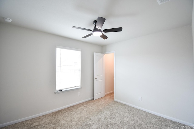 unfurnished room with light colored carpet, baseboards, and ceiling fan