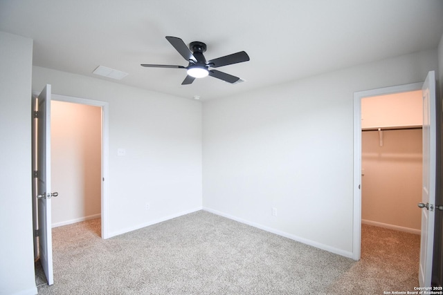 unfurnished bedroom with baseboards, carpet floors, a closet, and a spacious closet