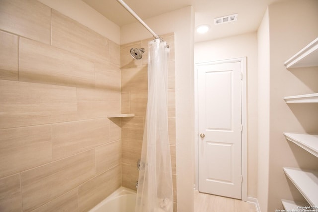 bathroom featuring visible vents and shower / tub combo with curtain