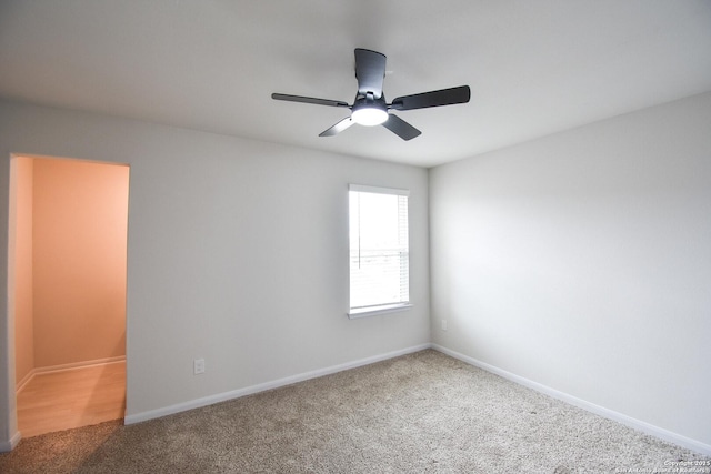 carpeted spare room with baseboards and ceiling fan