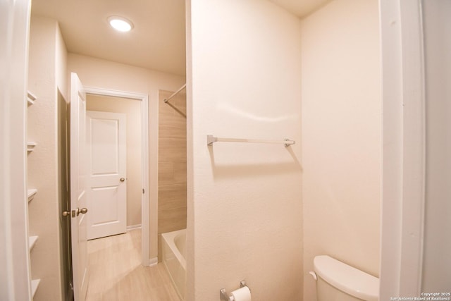 full bathroom featuring toilet, shower / washtub combination, and wood finished floors