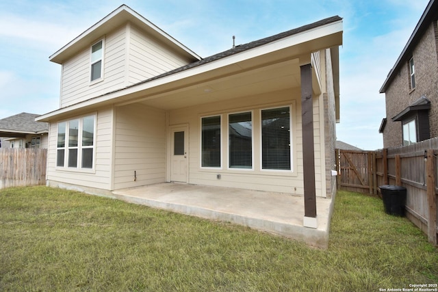 rear view of house with a patio area, a lawn, and a fenced backyard