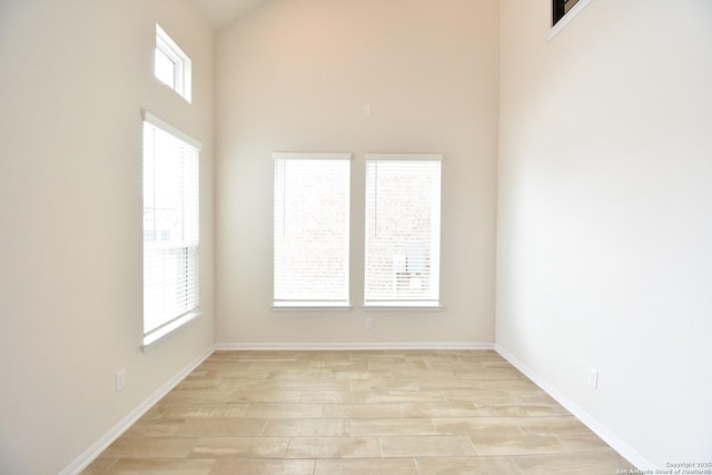 spare room featuring light wood finished floors and baseboards