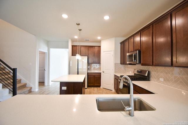 kitchen featuring backsplash, a center island, light countertops, stainless steel appliances, and a sink