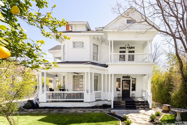 view of front of property with a chimney, a porch, a ceiling fan, and a balcony