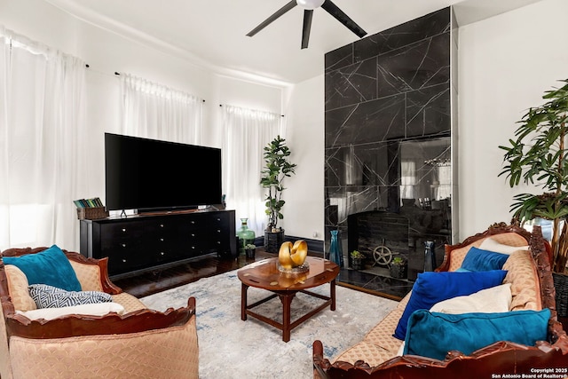 living room featuring a wood stove and a ceiling fan