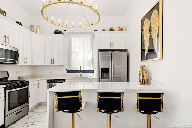 kitchen featuring a sink, marble finish floor, appliances with stainless steel finishes, and white cabinets