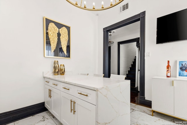 interior space featuring visible vents, baseboards, marble finish floor, and stairway