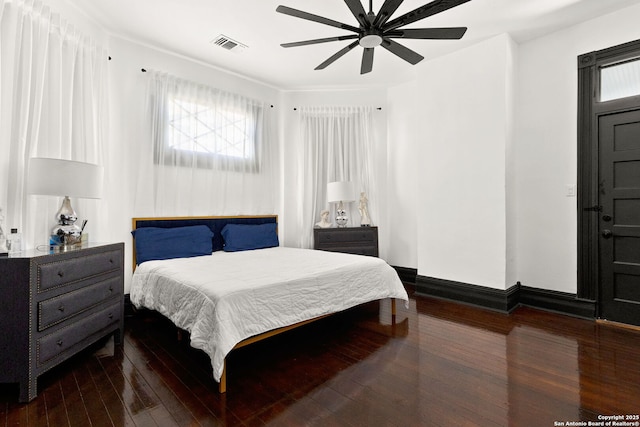 bedroom featuring visible vents, ceiling fan, baseboards, and hardwood / wood-style flooring