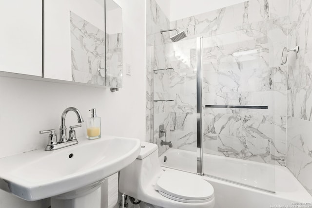 bathroom featuring shower / washtub combination, toilet, and a sink