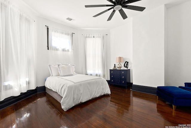 bedroom featuring visible vents, a ceiling fan, baseboards, and wood-type flooring