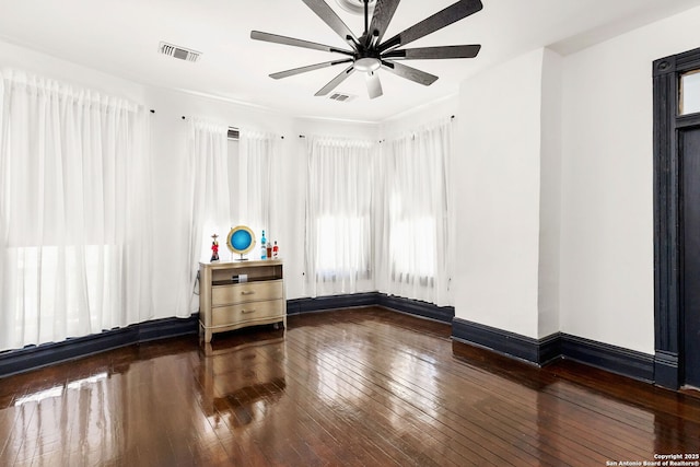 unfurnished room featuring visible vents, a ceiling fan, baseboards, and wood-type flooring