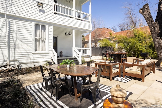 view of patio / terrace with an outdoor living space, a balcony, and outdoor dining area