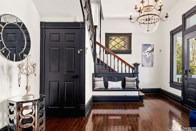 foyer entrance with a chandelier, stairs, baseboards, and hardwood / wood-style floors