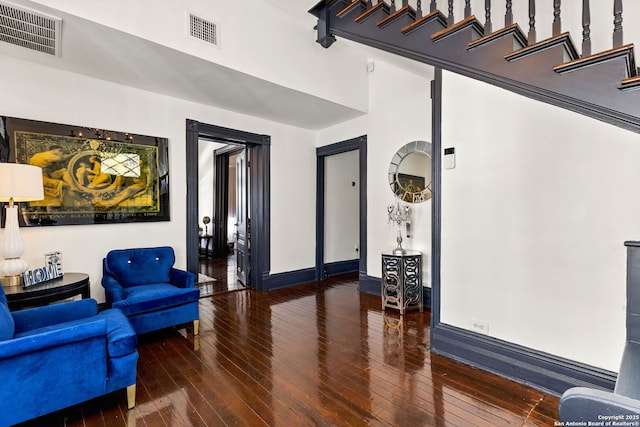 living area featuring visible vents, wood-type flooring, and baseboards