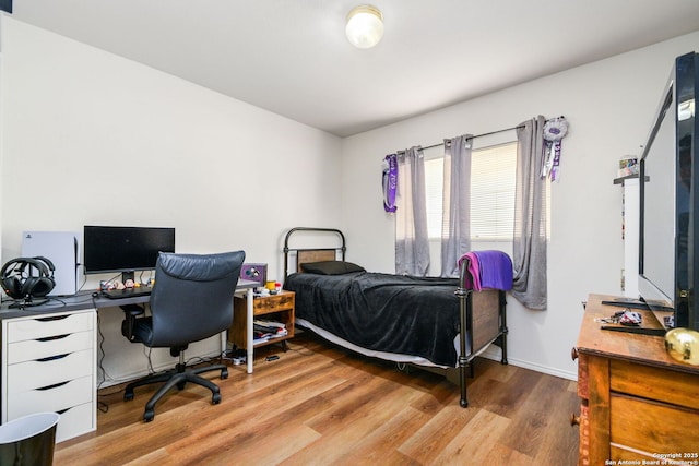 bedroom featuring wood finished floors and baseboards