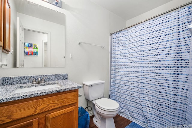 bathroom with curtained shower, toilet, vanity, and wood finished floors