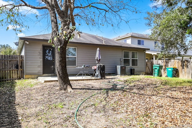 back of property with central air condition unit, a patio, and fence