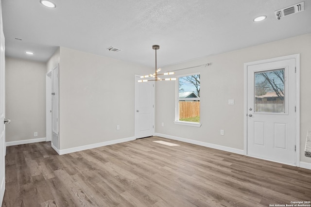 unfurnished dining area featuring wood finished floors, visible vents, and baseboards