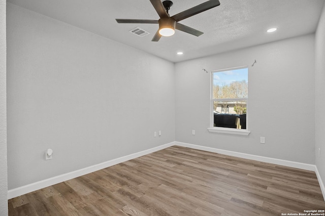 spare room featuring visible vents, wood finished floors, recessed lighting, baseboards, and ceiling fan