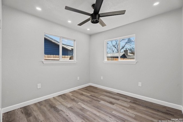 unfurnished room featuring a healthy amount of sunlight, baseboards, and wood finished floors