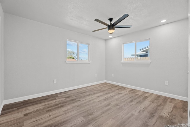 unfurnished room featuring a textured ceiling, wood finished floors, recessed lighting, baseboards, and ceiling fan