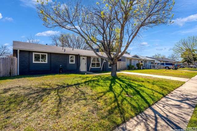 ranch-style house with brick siding, driveway, a front lawn, and fence