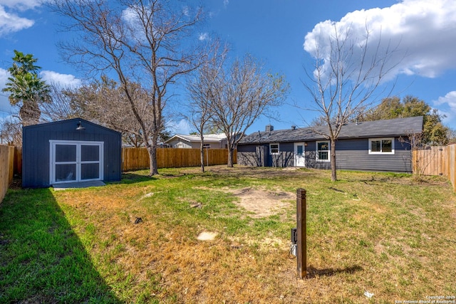 view of yard featuring an outdoor structure, a storage shed, and a fenced backyard