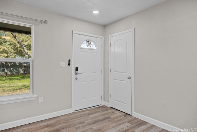 foyer entrance with recessed lighting, baseboards, and light wood finished floors