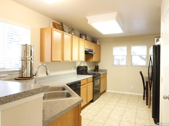 kitchen featuring black appliances, a wealth of natural light, under cabinet range hood, and light brown cabinetry