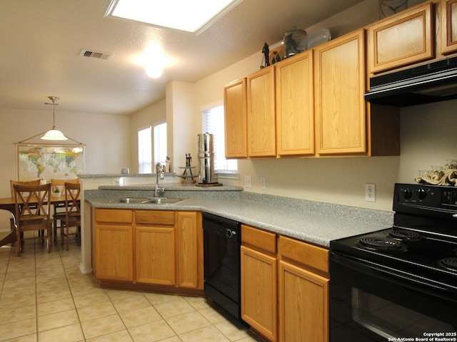 kitchen with a sink, black appliances, light countertops, under cabinet range hood, and decorative light fixtures