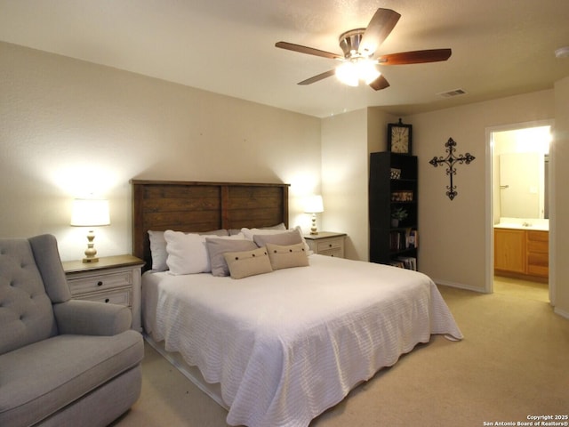 bedroom featuring visible vents, ensuite bathroom, a ceiling fan, baseboards, and light colored carpet