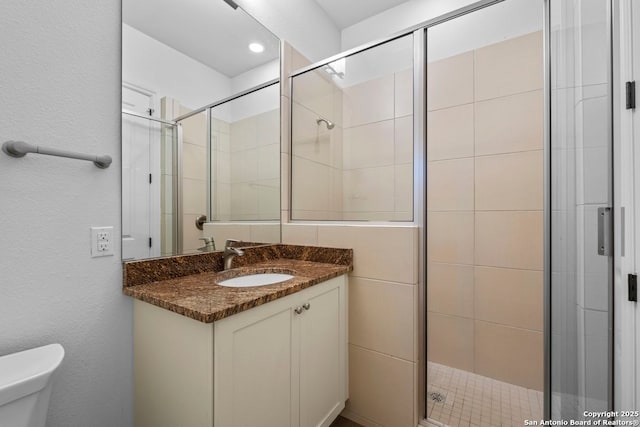 full bath featuring a stall shower, toilet, and vanity