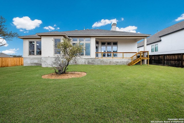 rear view of property featuring stucco siding, a lawn, a fenced backyard, and a chimney