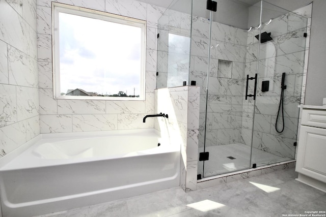 bathroom featuring a marble finish shower and a bath