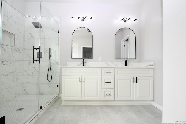 bathroom with double vanity, baseboards, a marble finish shower, and a sink