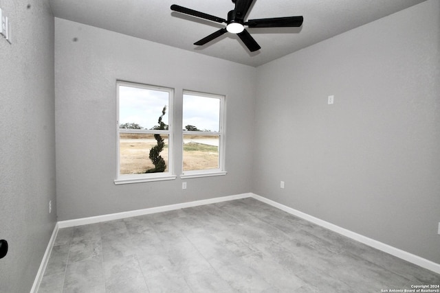 empty room with ceiling fan and baseboards