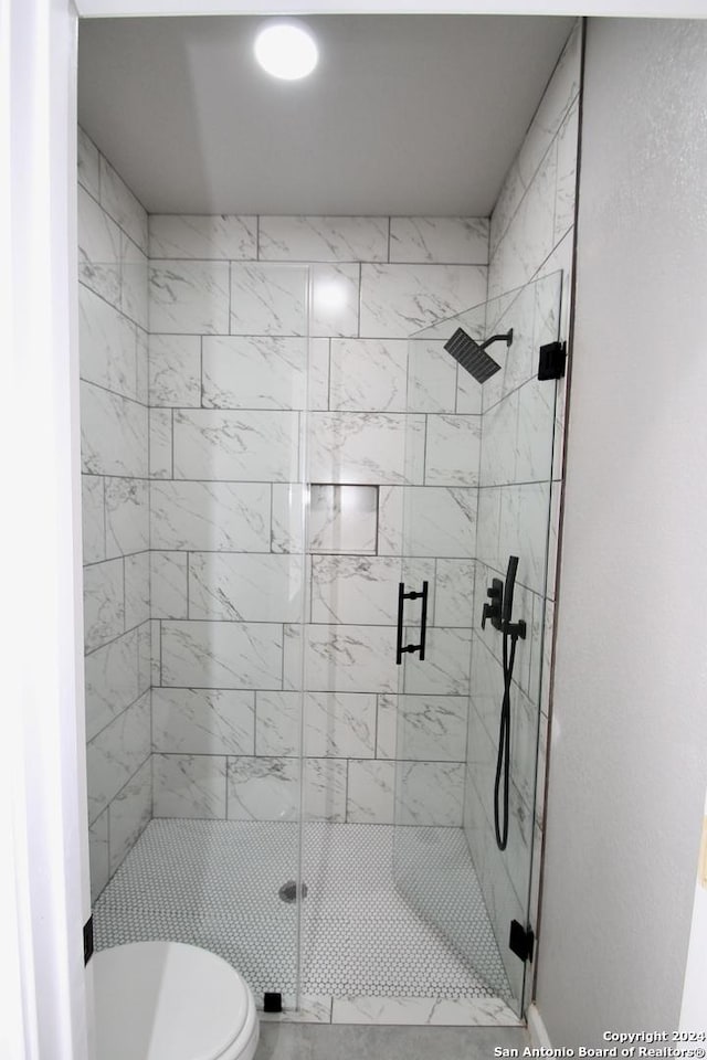 full bath with toilet and a stall shower