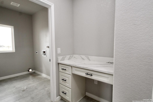 bathroom with visible vents, baseboards, vanity, and a textured wall